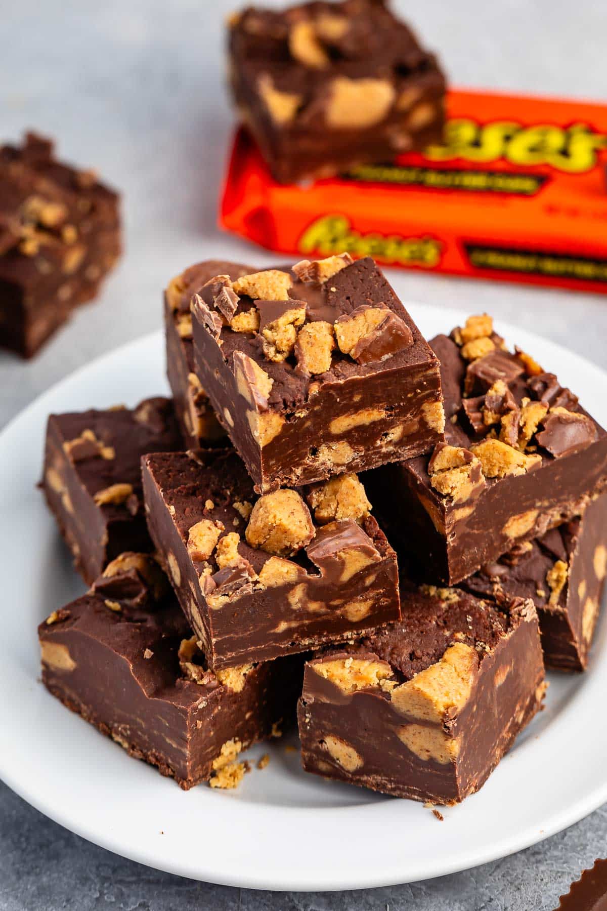 stacked brown reeses fudge on a white plate.