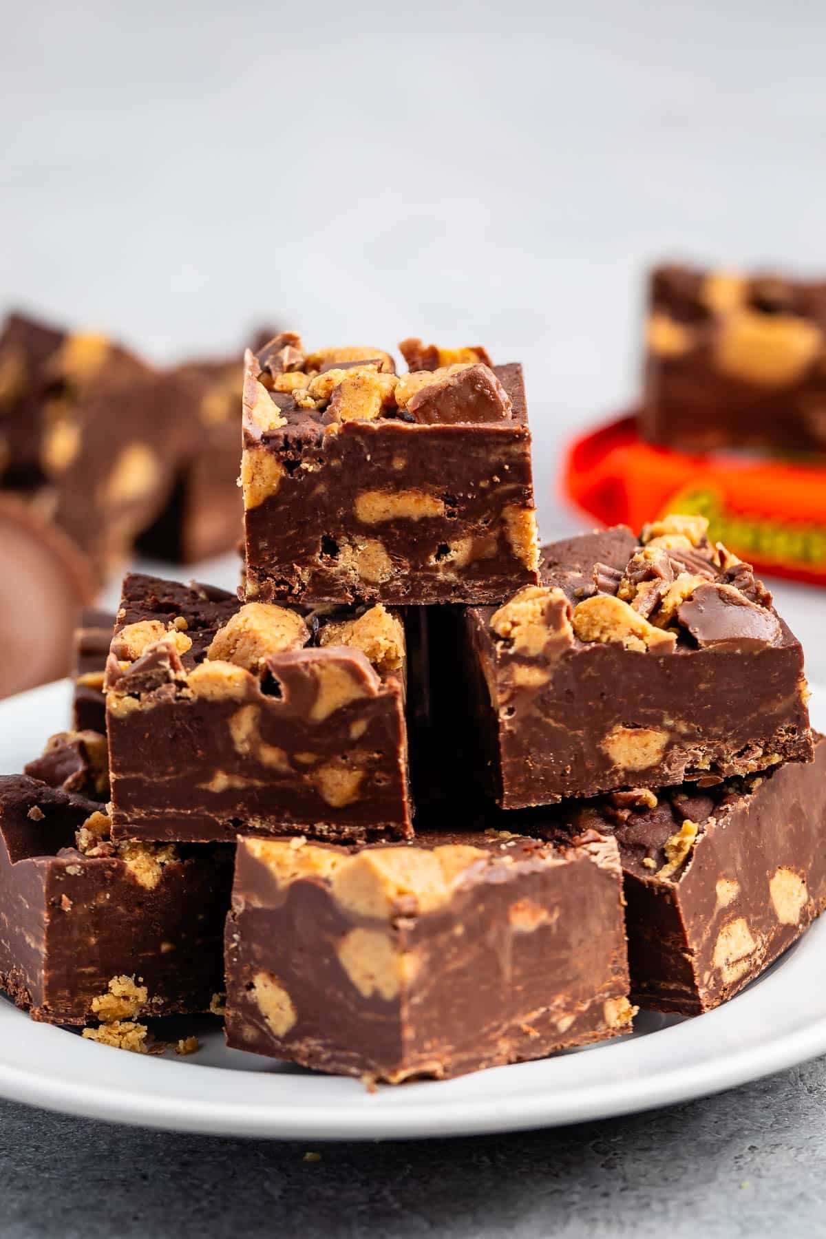 stacked brown reeses fudge on a white plate.