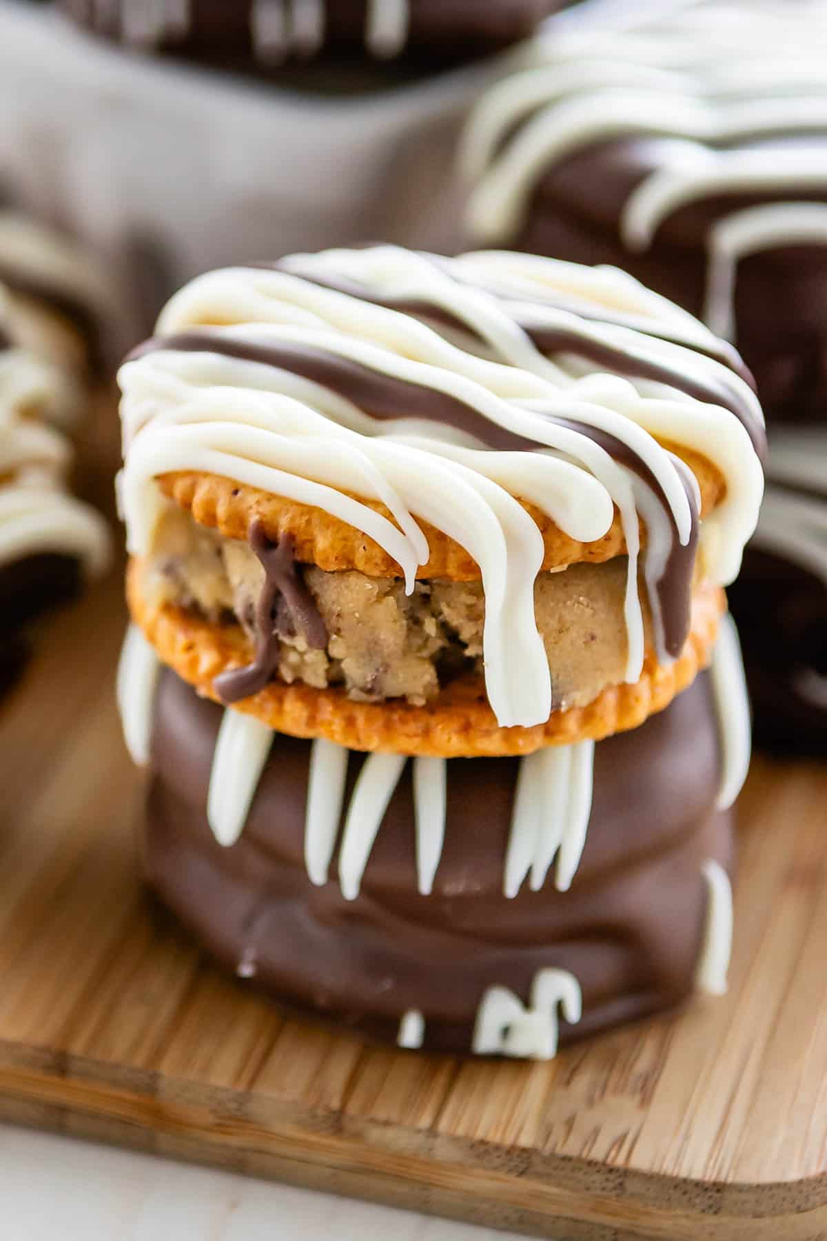 stacked ritz crackers covered in chocolate with cookie dough in the middle.