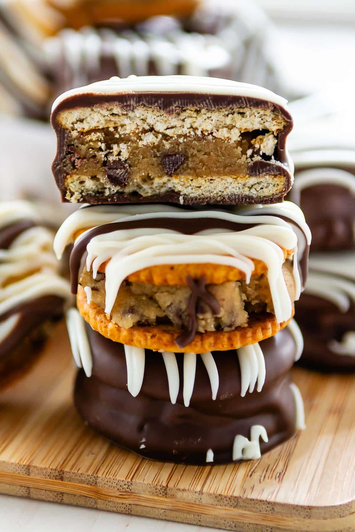 stacked ritz crackers covered in chocolate with cookie dough in the middle.