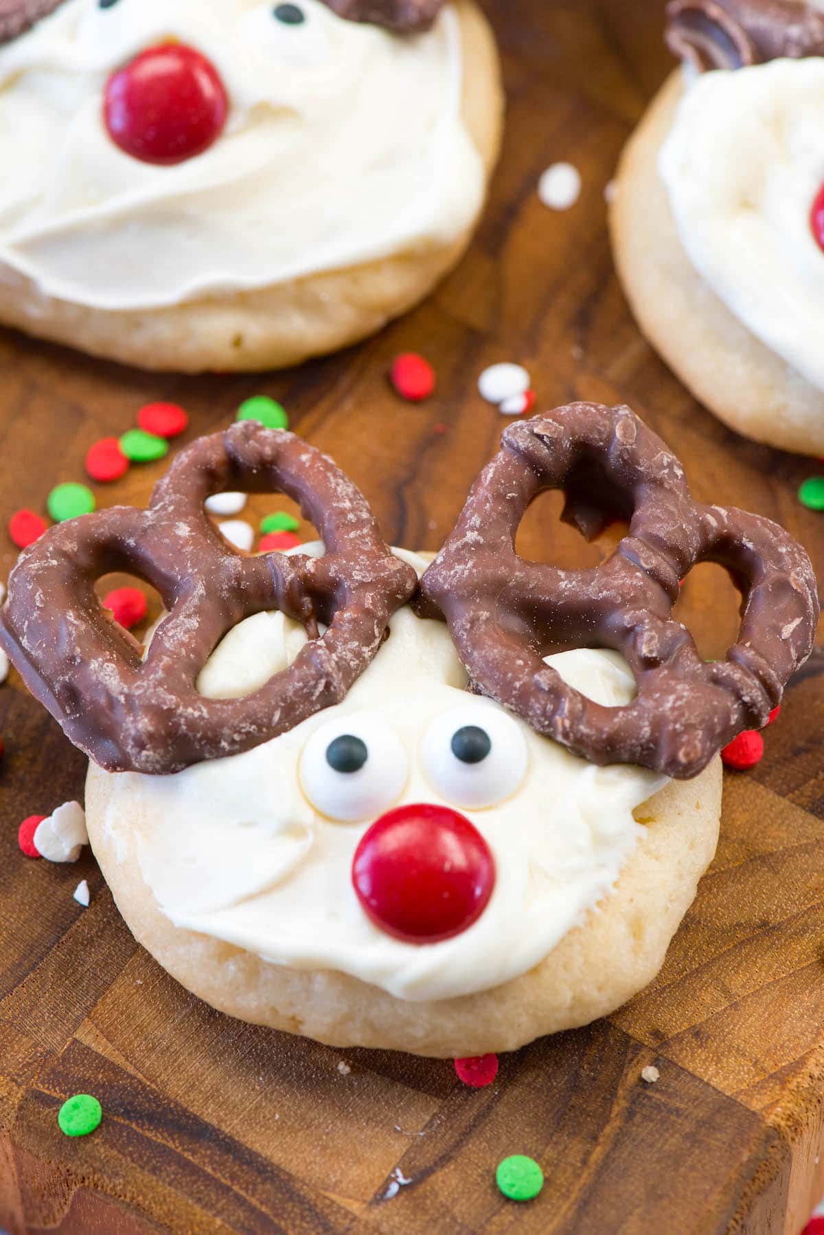 cookie with white frosting and candy on top to make the cookie look like a reindeers face.