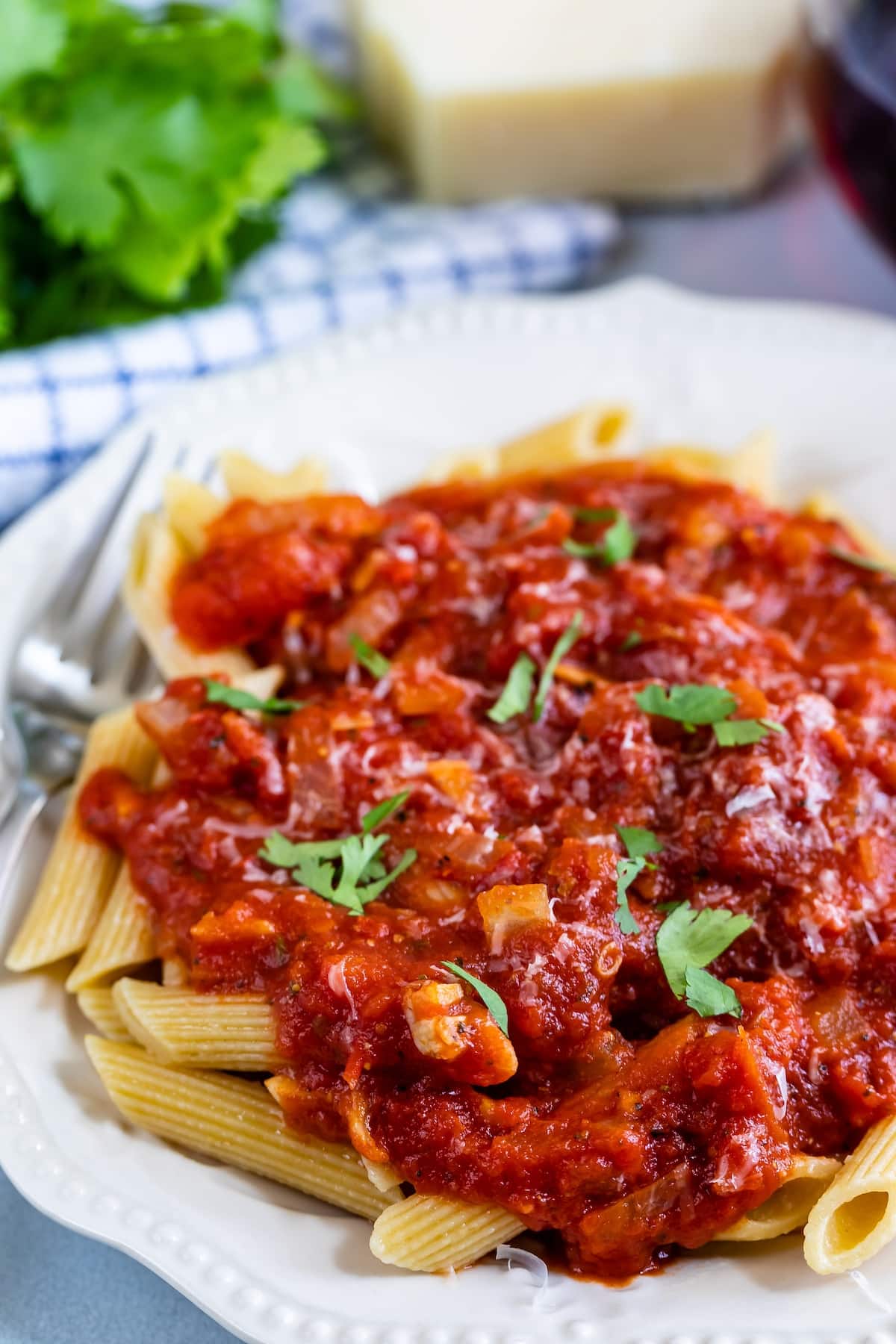 red pasta sauce on top of pasta on a white plate.