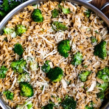 pasta mixed with broccoli in a silver skillet.