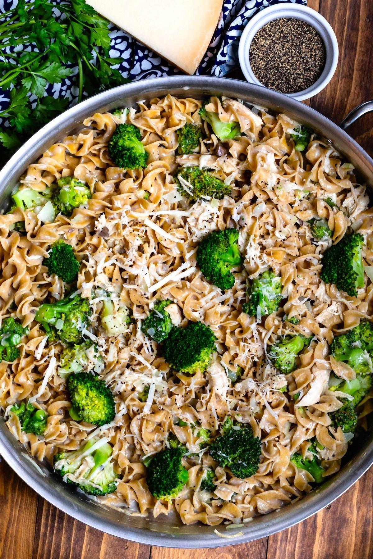 pasta mixed with broccoli in a silver skillet.
