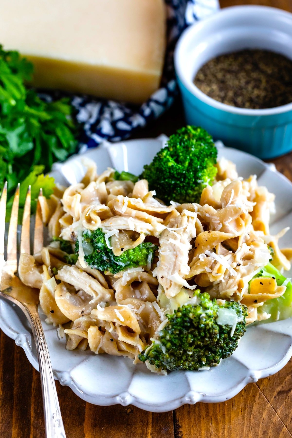 pasta and chicken mixed with broccoli on a grey plate.