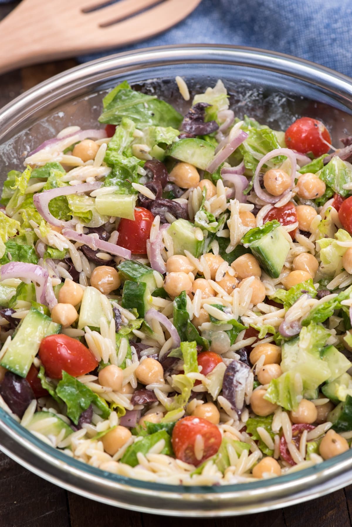 salad mixed together with dressing in a clear bowl.