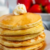 a stack of pancakes with syrup and butter on top.