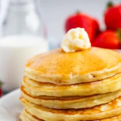 a stack of pancakes with syrup and butter on top.