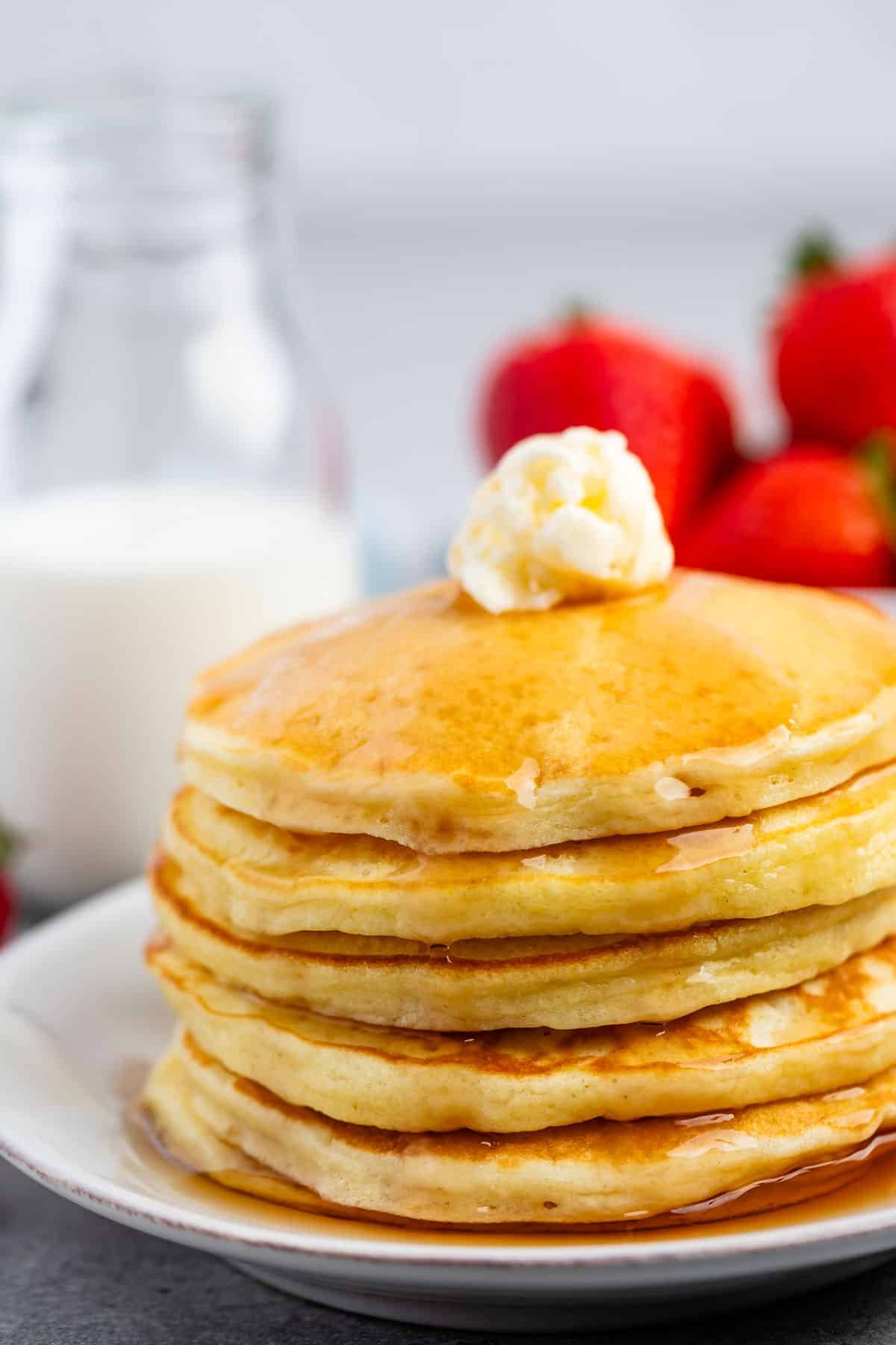 a stack of pancakes with syrup and butter on top.