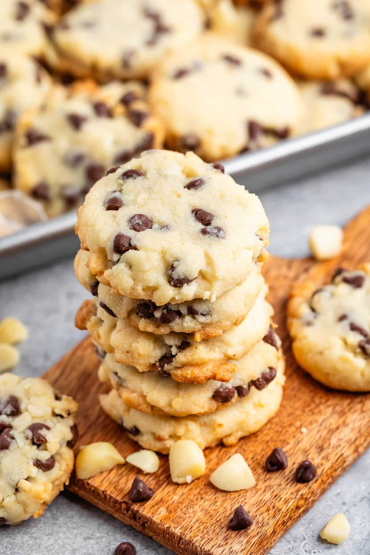 stacked cookies with chocolate chips baked into the cookie on a cutting board.