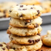 stacked cookies with chocolate chips baked into the cookie on a cutting board.