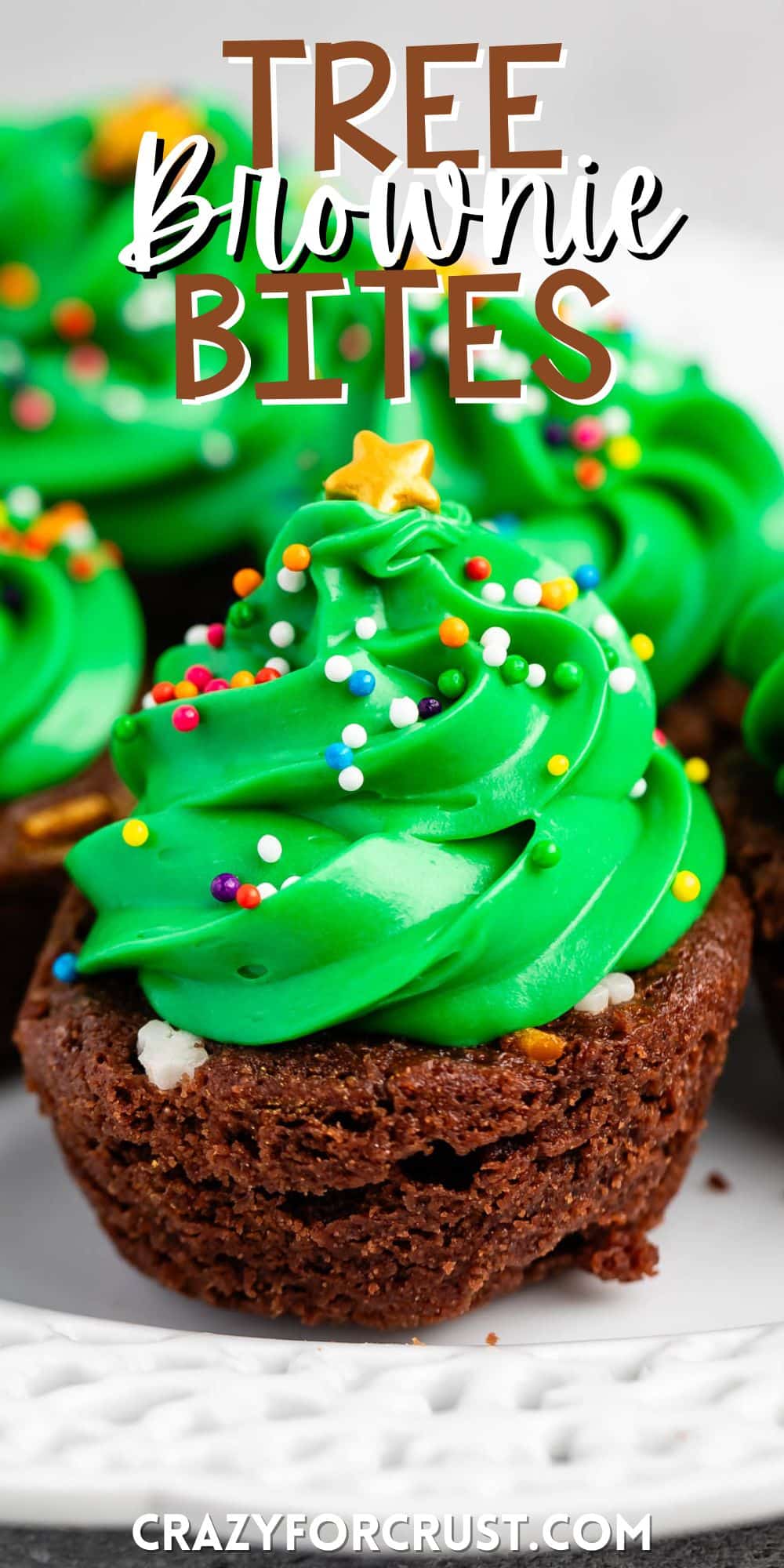 brownie bite on a white plate with green frosting and sprinkles on top replicating a christmas tree and ornaments with words on the image.