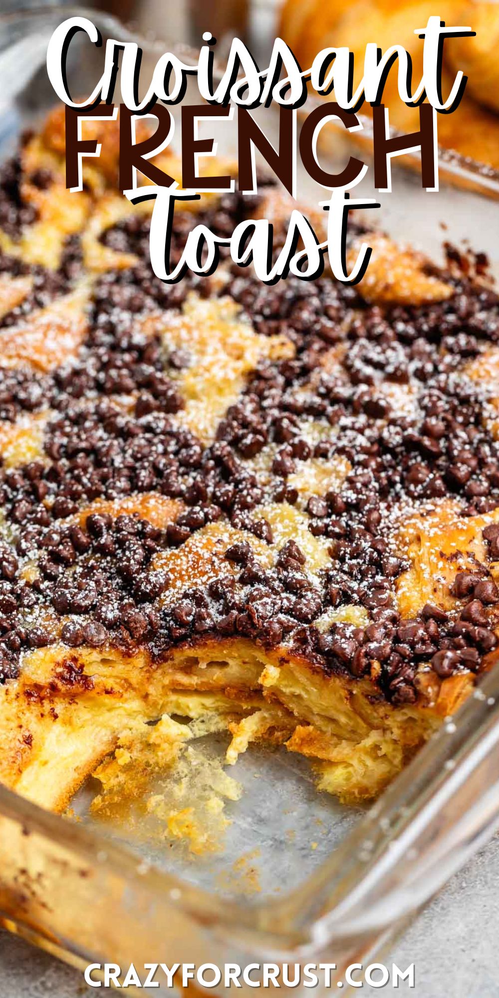 French toast in a square clear pan with chocolate chips and powdered sugar sprinkled on top with words on the image.