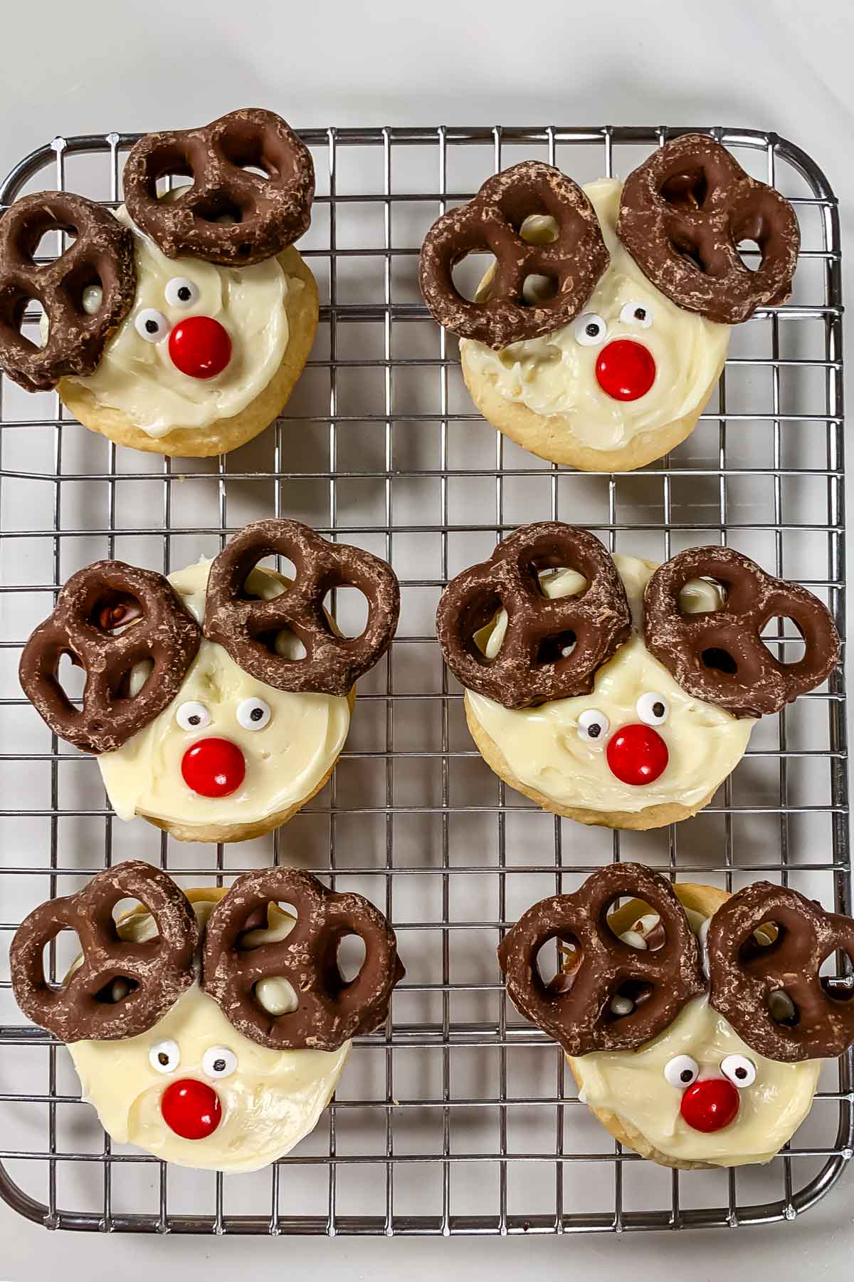 cookie with white frosting and candy on top to make the cookie look like a reindeers face.