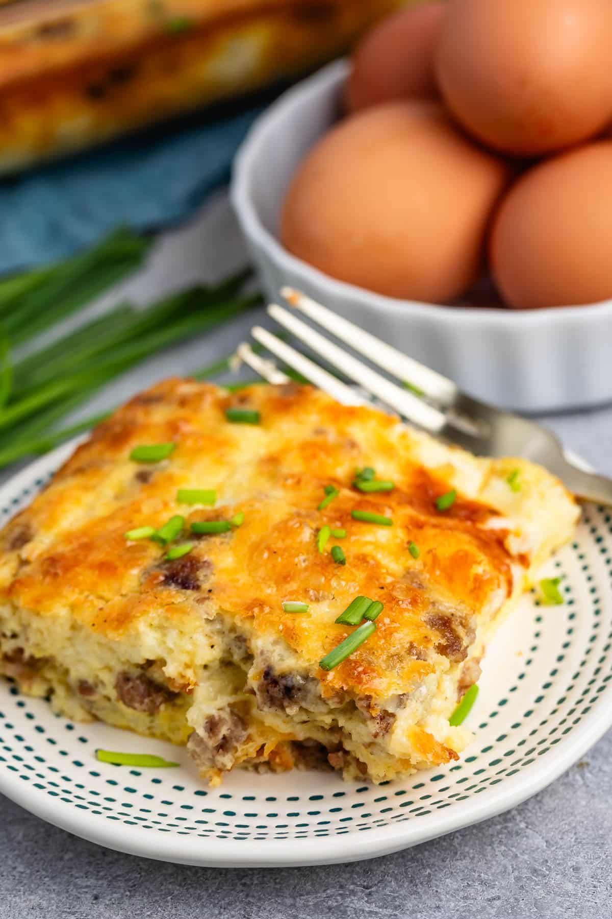 egg casserole with sausage baked in on a white plate.