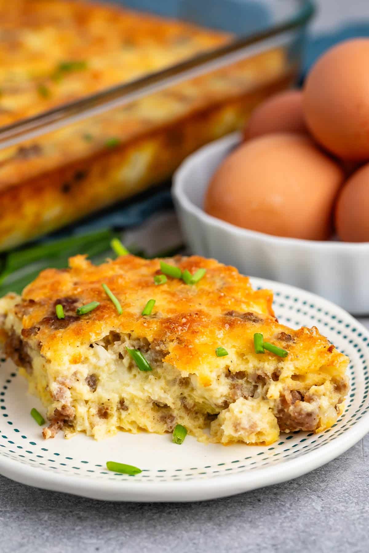 egg casserole with sausage baked in on a white plate.