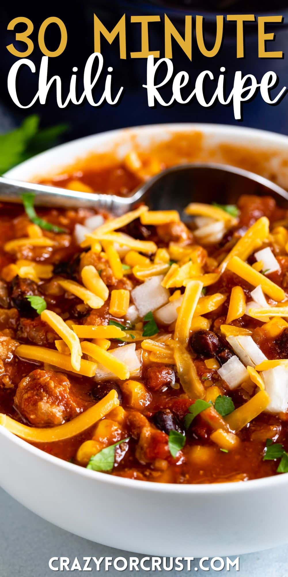 chili recipe with cheese on top in a white bowl with words on the image.