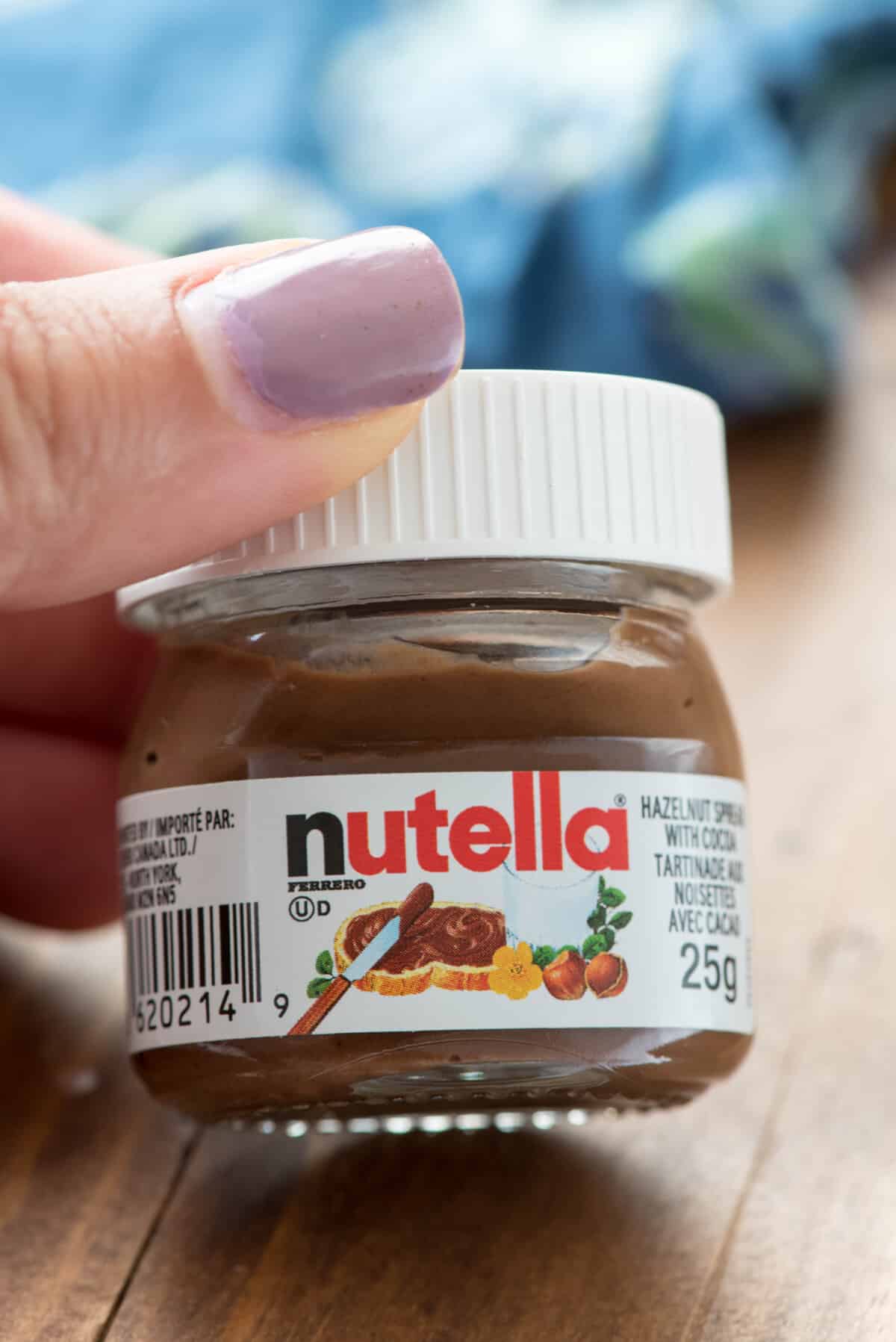 hand holding a little jar of nutella.