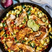 chicken and vegetables in a black skillet.