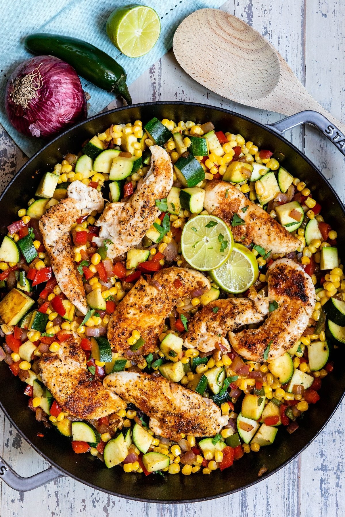 chicken and vegetables in a black skillet.