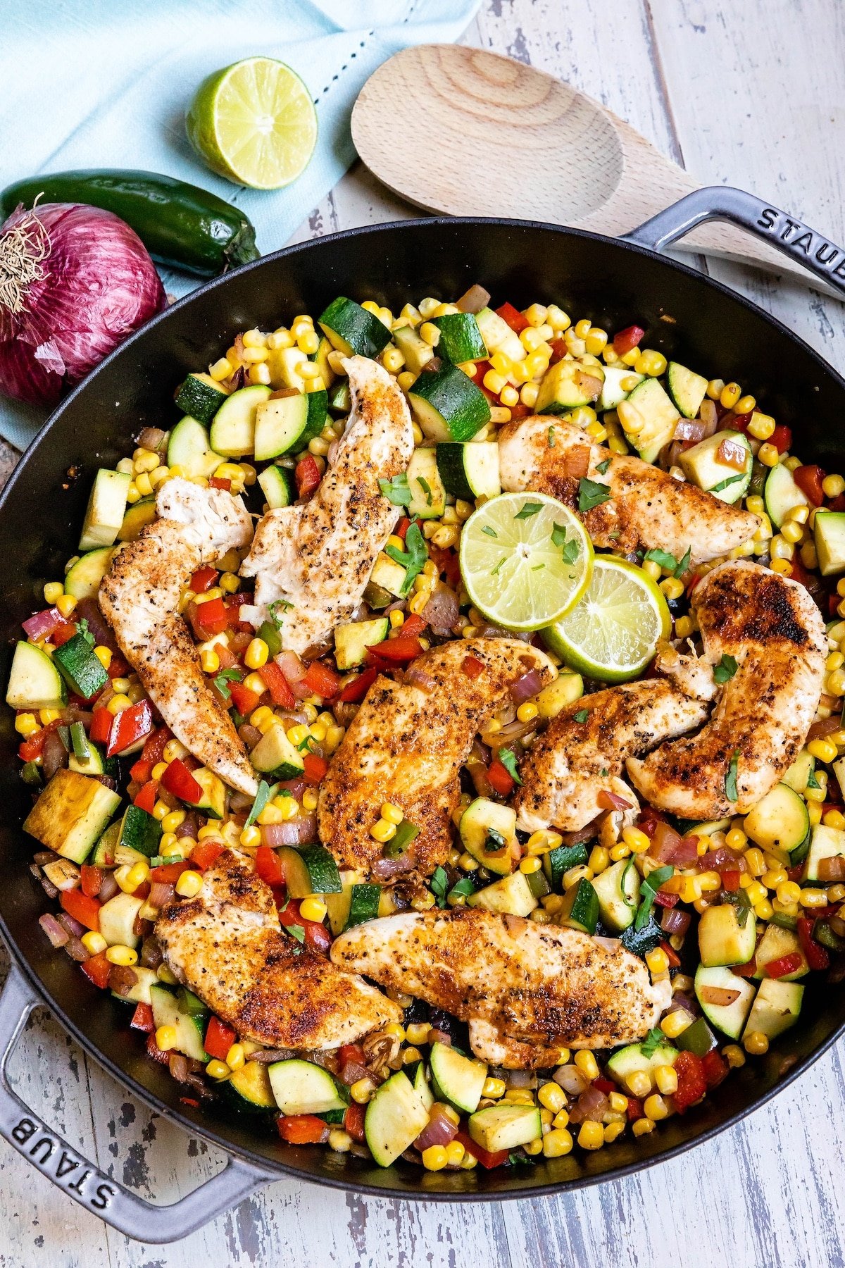 chicken and vegetables in a black skillet.