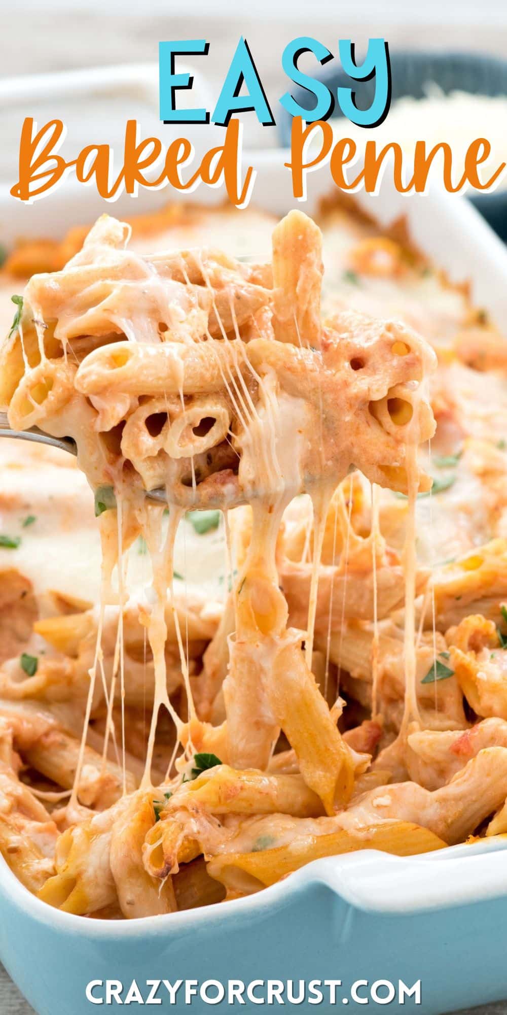 baked penne being scooped out of a teal pan with a silver spoon with words on the image.