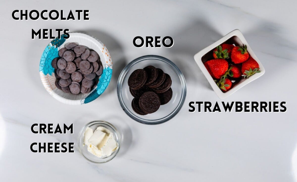 ingredients in oreo truffle dipped strawberries laid out on a white counter.
