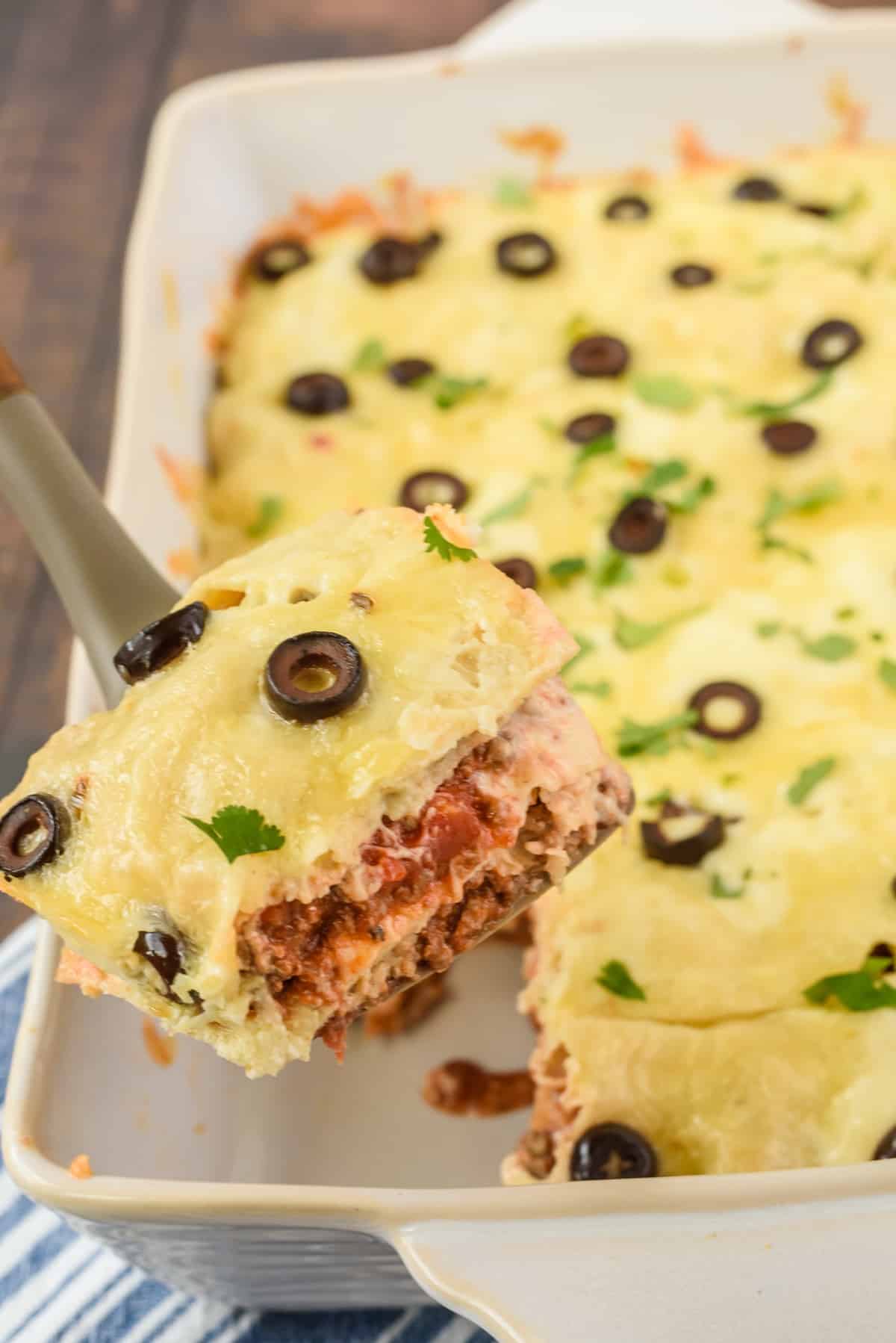 casserole with cheese and black olives and garnish on top in a white casserole pan