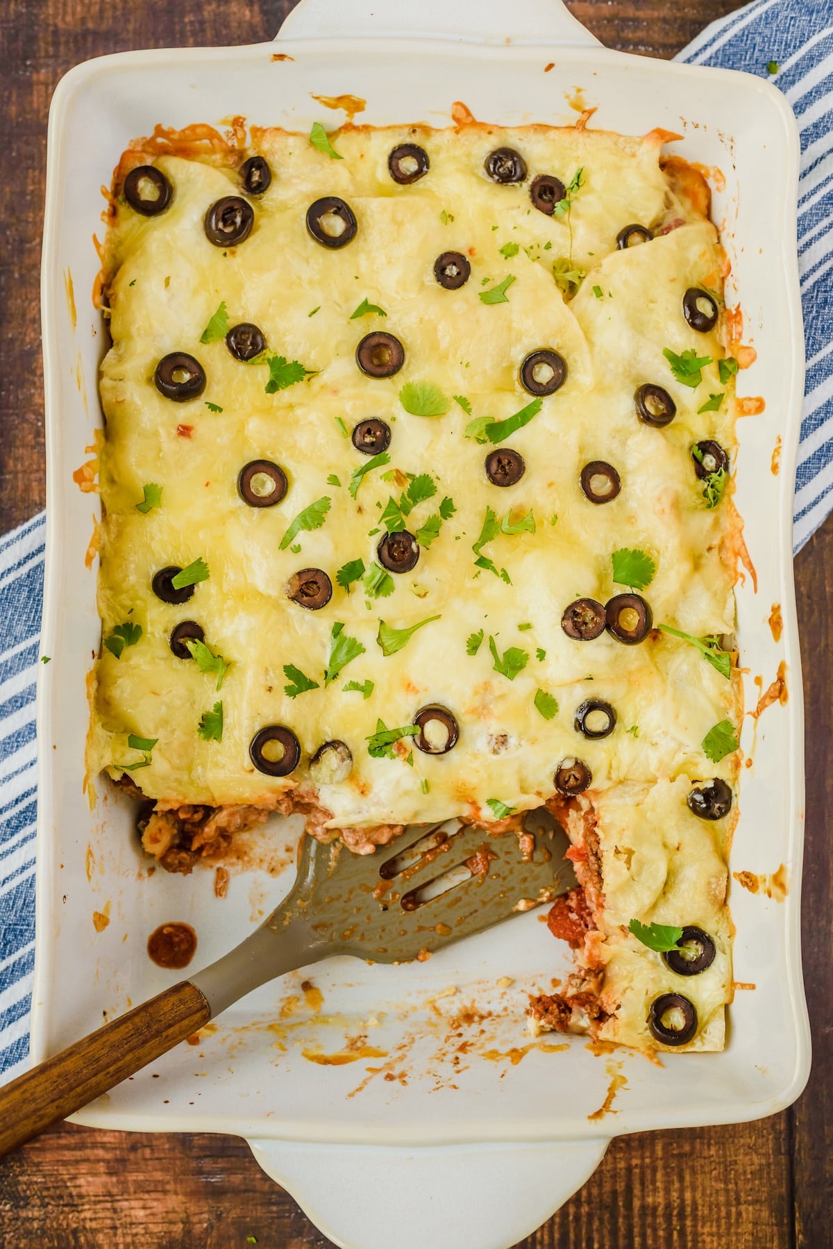 casserole with cheese and black olives and garnish on top in a white casserole pan