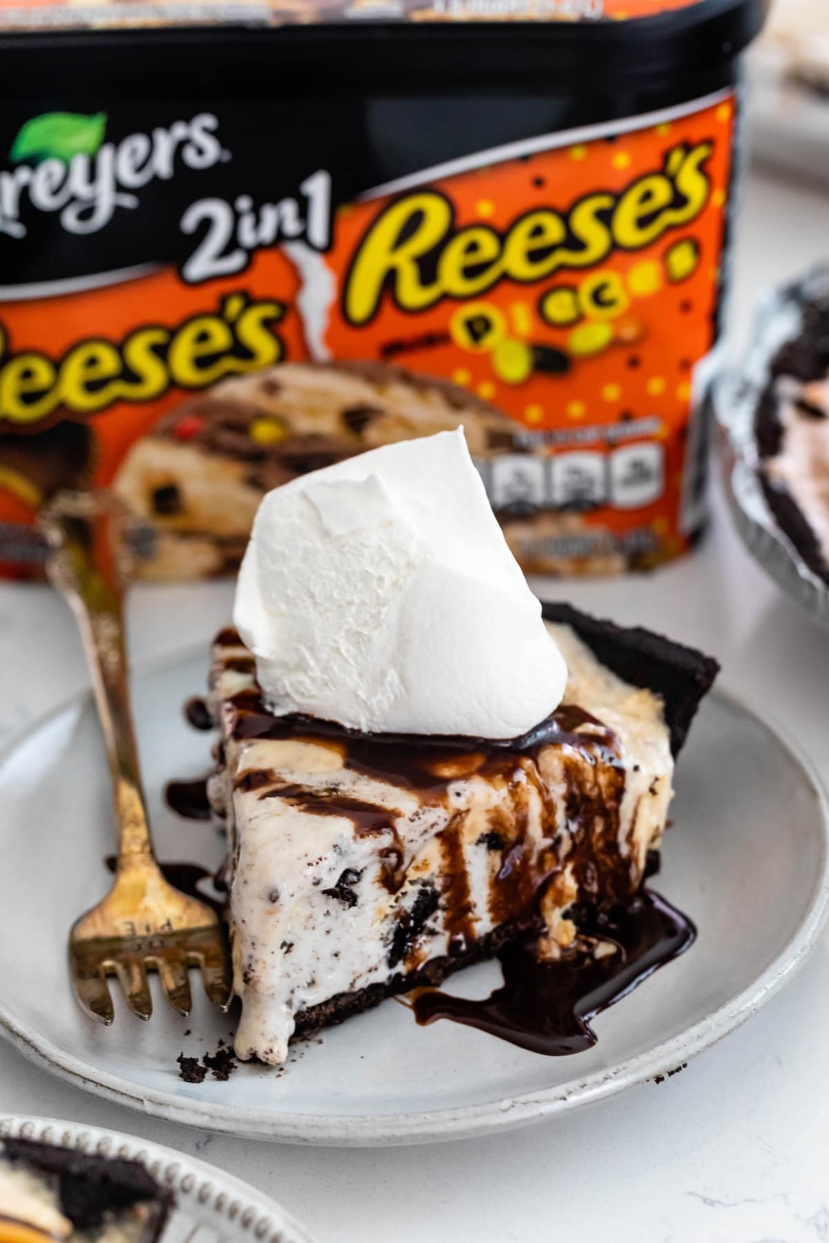 ice cream pie with chocolate on top on a grey plate.