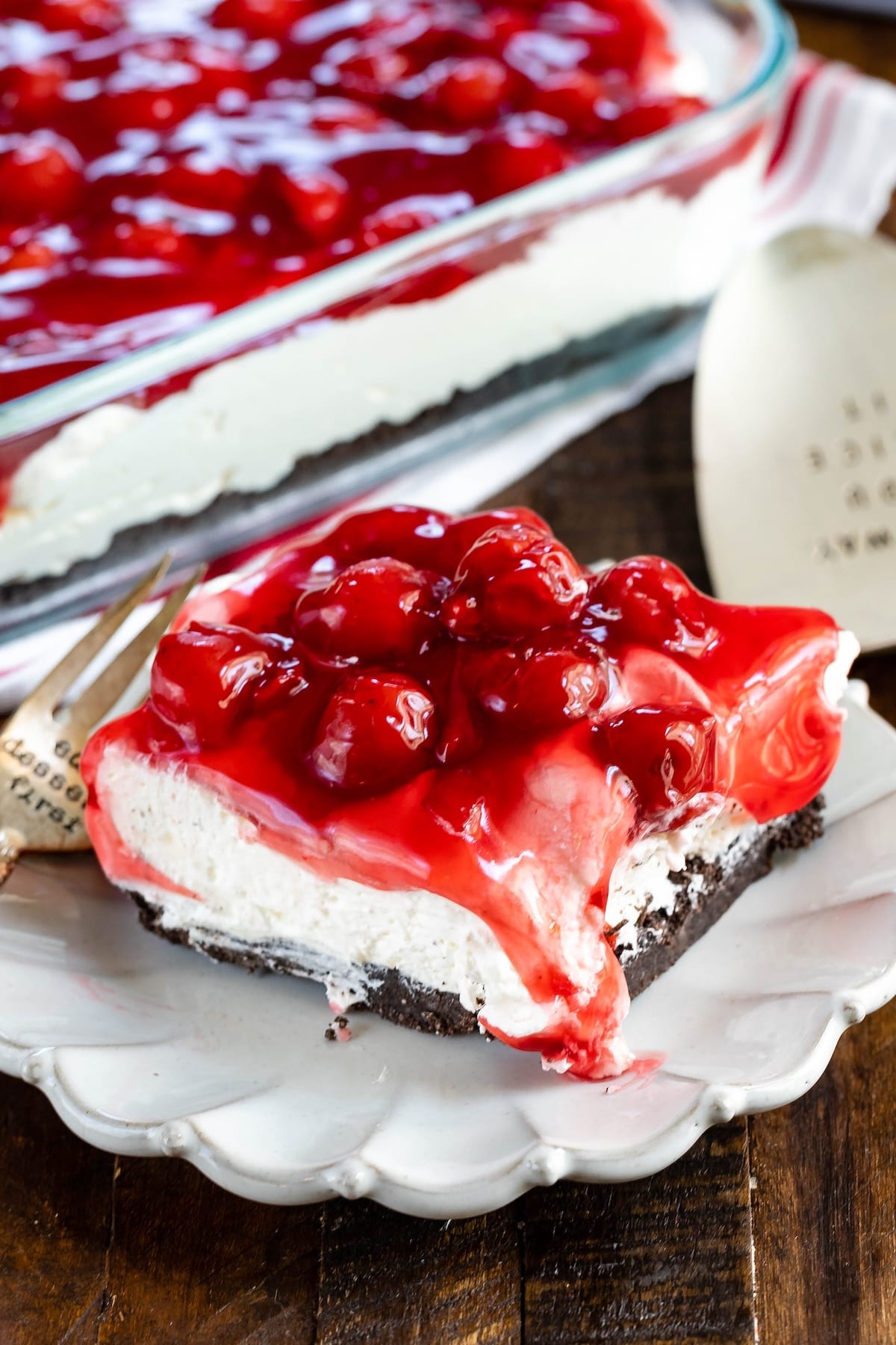 layered dessert topped with cherries.