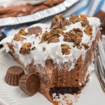 slice of chocolate pie on white plate with bite missing.