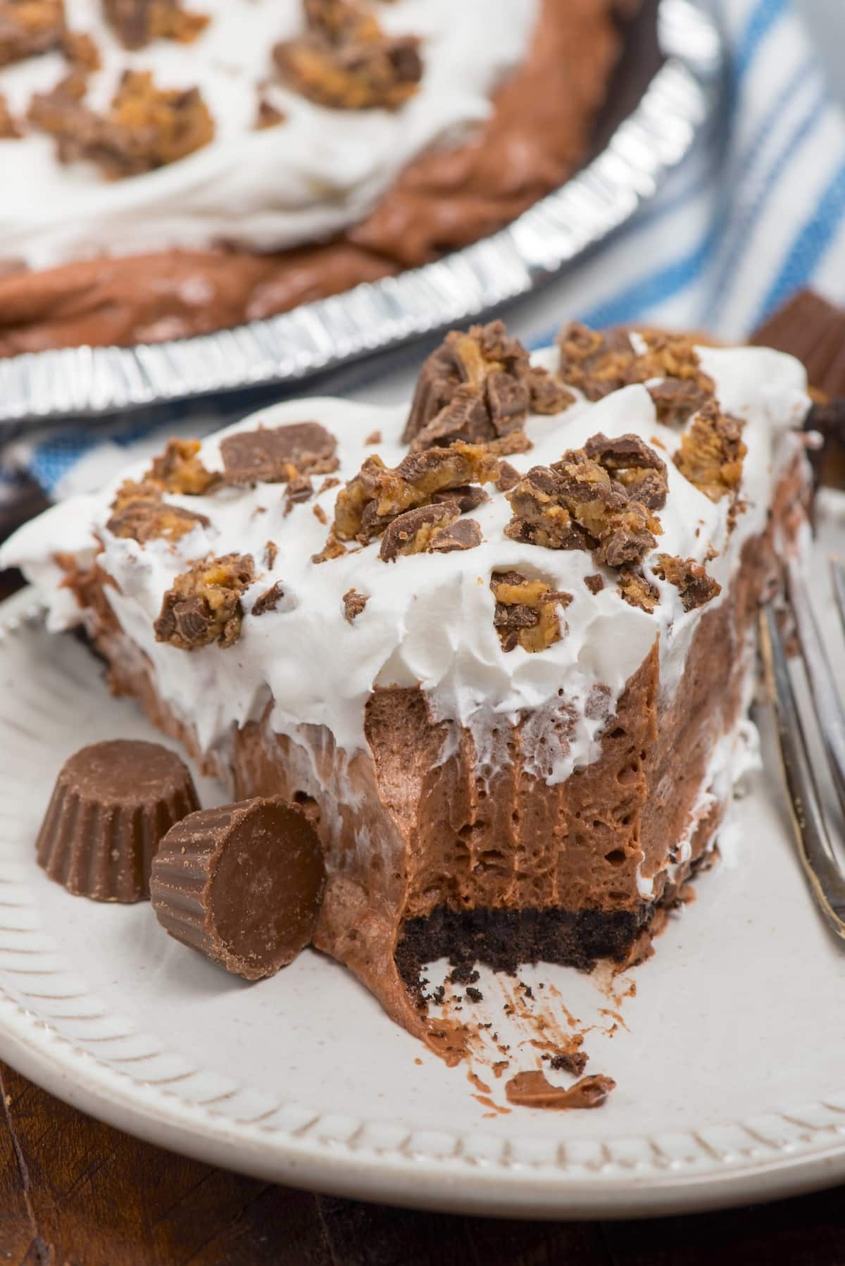 slice of chocolate pie on white plate with bite missing.