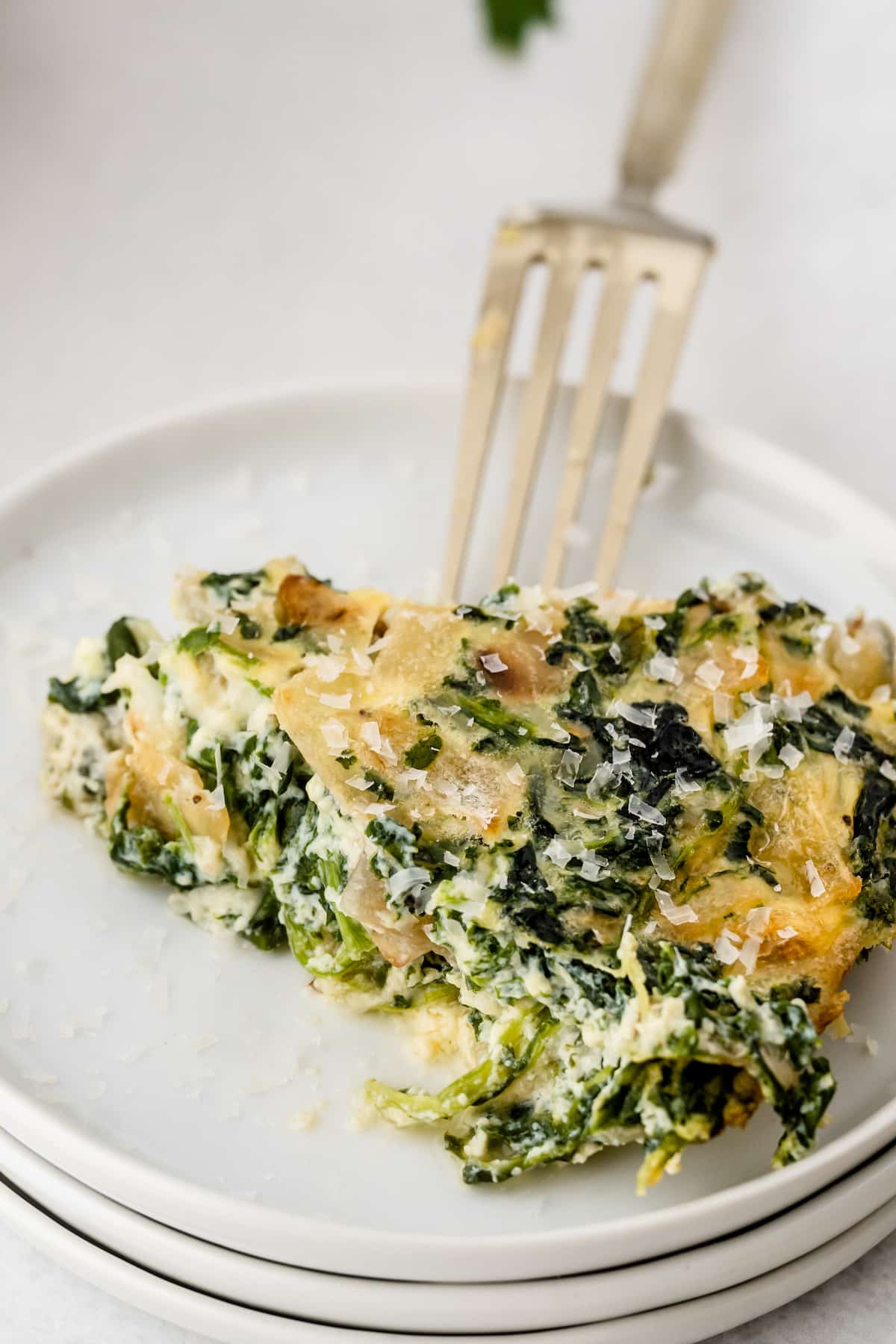 quiche made with spinach in a white dish.