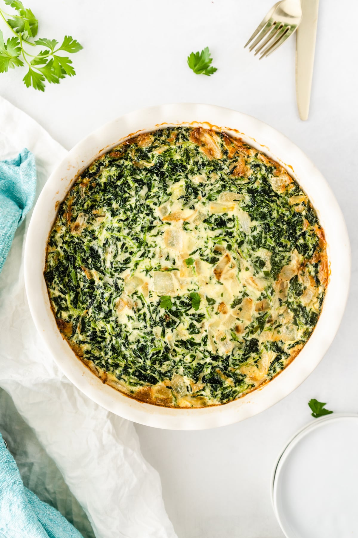 quiche made with spinach in a white dish.