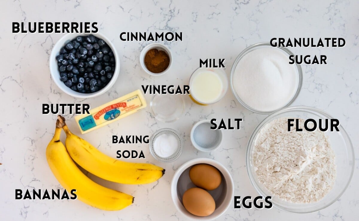 ingredients in blueberry banana bread laid out on a marble counter.