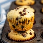 stacked muffins in the baking pan with mini chocolate chips baked in.