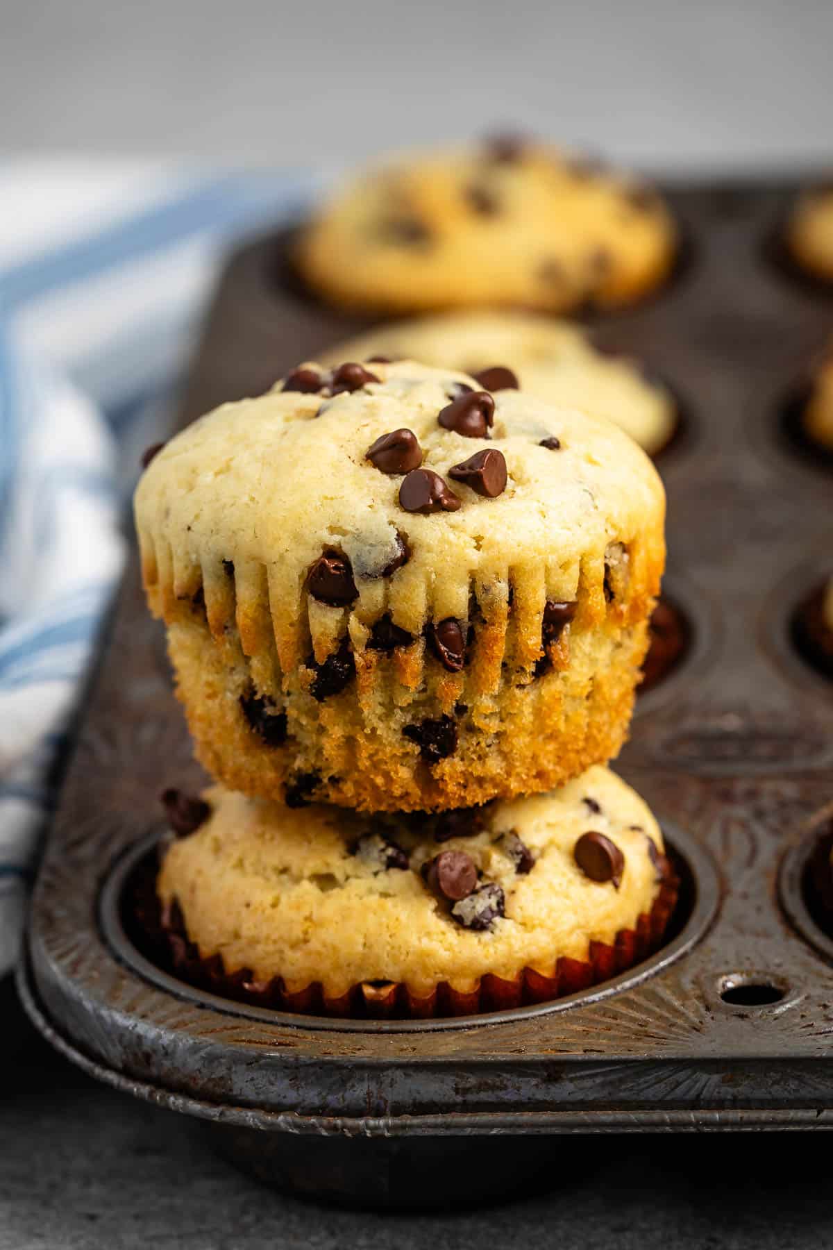 stacked muffins in the baking pan with mini chocolate chips baked in.