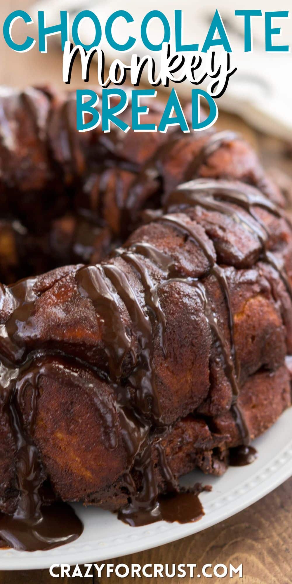 round monkey bread on a white plate with chocolate oozing with the sides with words on the image.