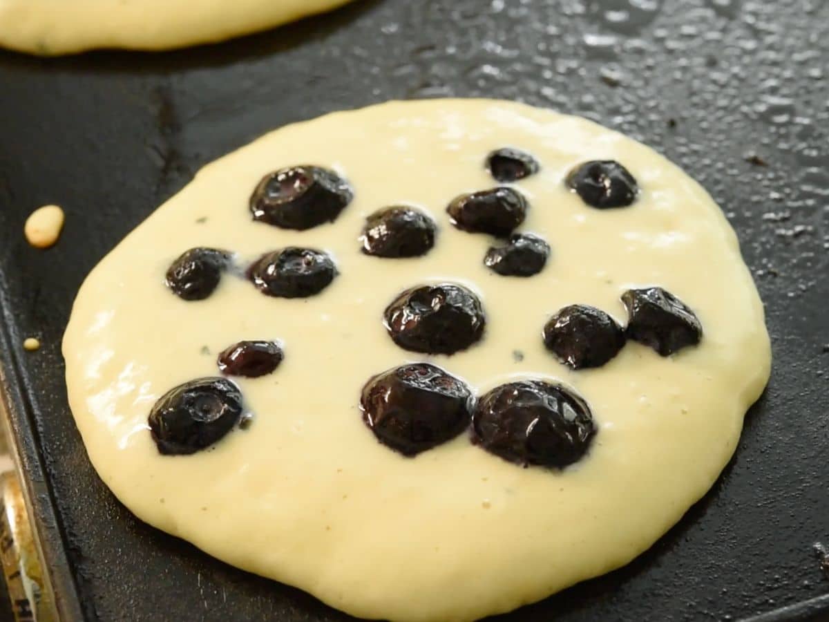 process shot of fluffy blueberry pancakes being made.