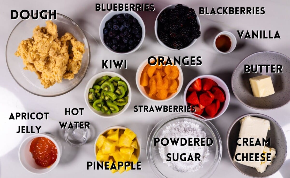 ingredients in fruit pizza laid out on a marble counter.