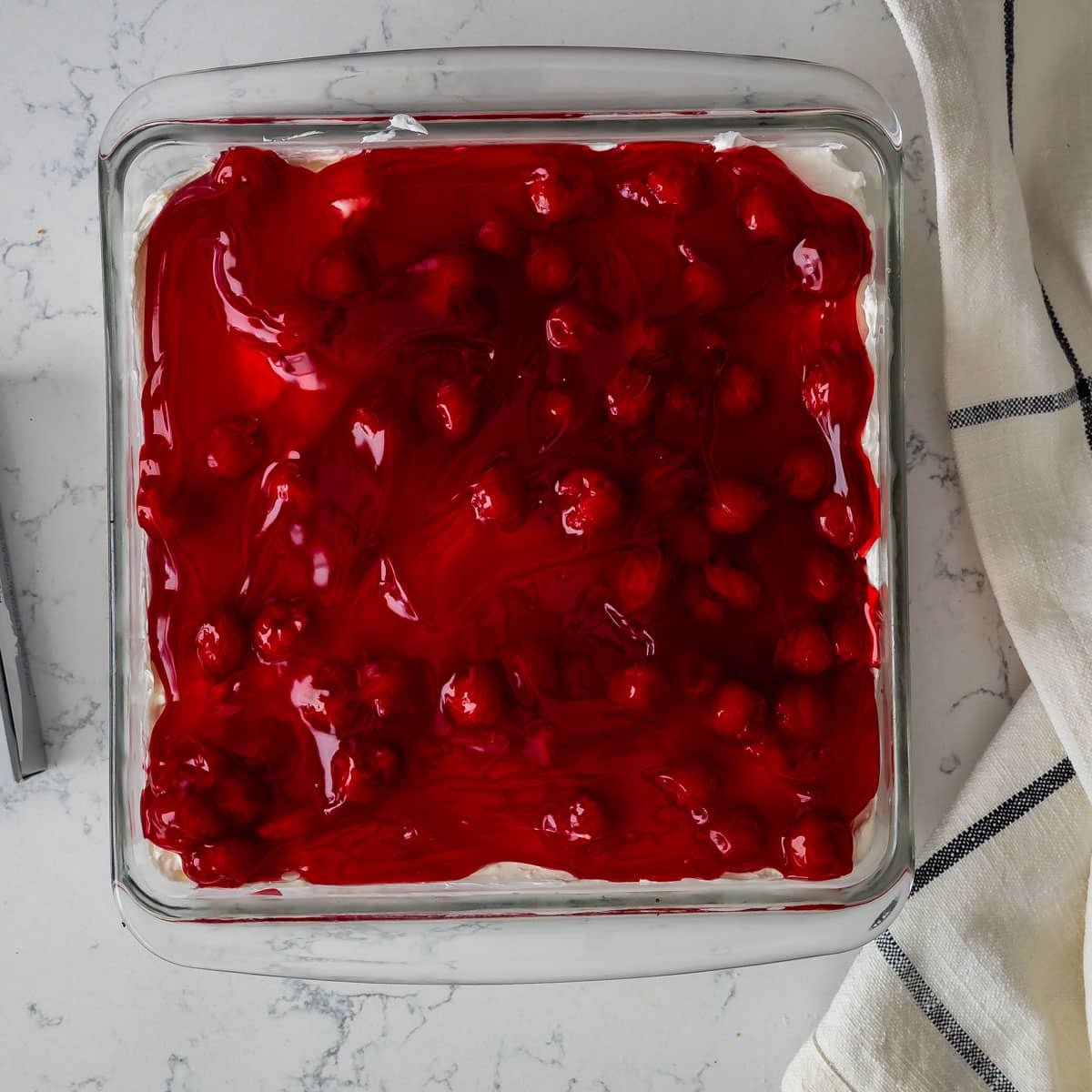 process shot of cherry cheesecake dessert being made.