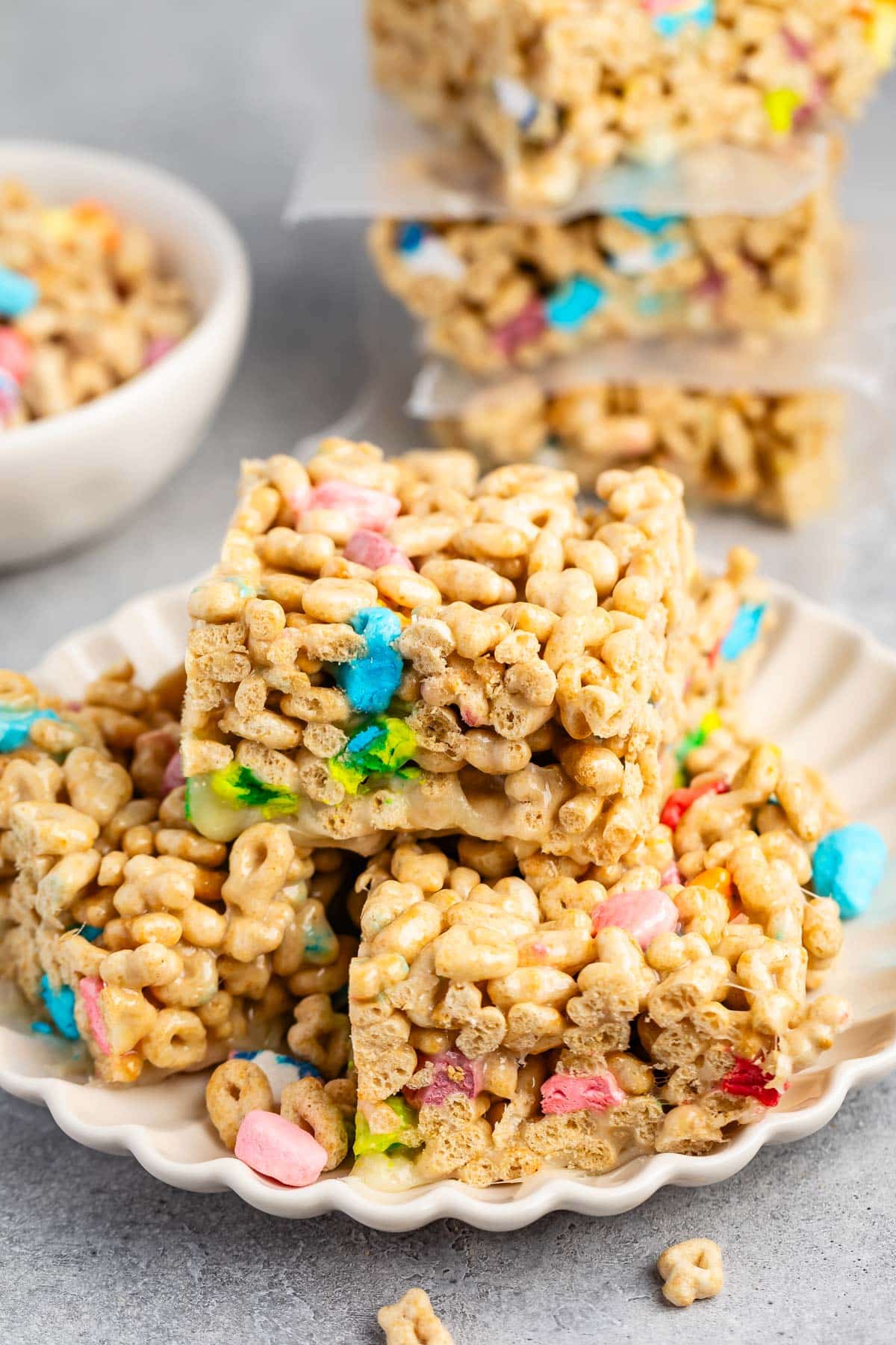 stacked Rice Krispie treats made from lucky charms on a white plate.