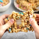 Rice Krispie treats made from lucky charms being pulled apart with hands.