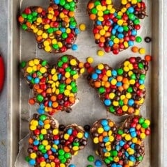 Mickey Mouse shaped Rice Krispie treats covered in chocolate and colorful M&Ms.