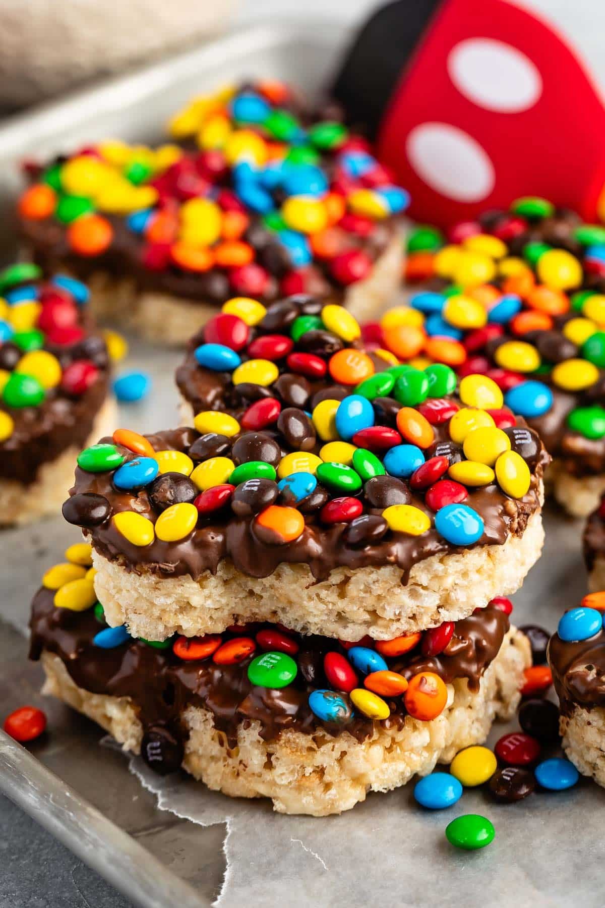 Mickey Mouse shaped Rice Krispie treats covered in chocolate and colorful M&Ms.