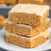 stacked peanut butter bars on a white plate.