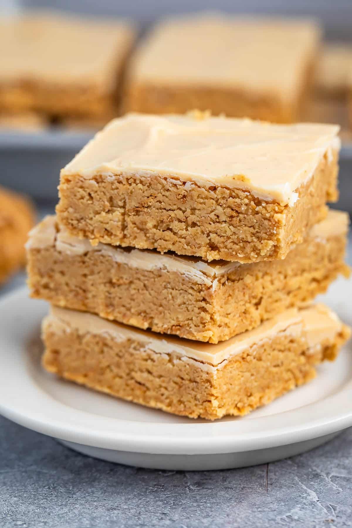 stacked peanut butter bars on a white plate.