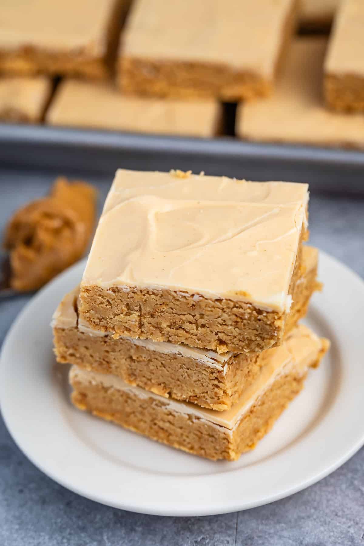 stacked peanut butter bars on a white plate.