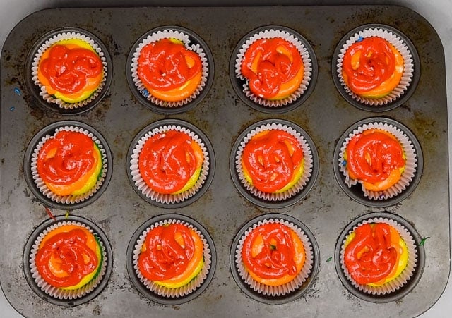 cake batter layered in cupcake pans.